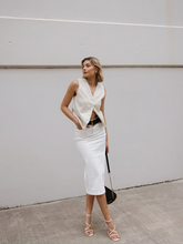 a lady wears a white denim skirt with a white vest